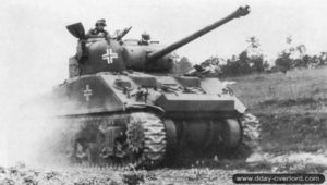 Un char Sherman Firefly ayant appartenu au 148th Royal Armored Corps, 33rd Armored Brigade, est capturé et testé par le Schwere Panzer-Abteilung 503 au nord-est de Giberville. Photo : Bundesarchiv