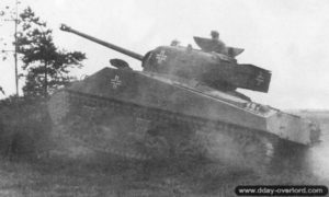 Un char Sherman Firefly ayant appartenu au 148th Royal Armored Corps, 33rd Armored Brigade, est capturé et testé par le Schwere Panzer-Abteilung 503 au nord-est de Giberville. Photo : Bundesarchiv