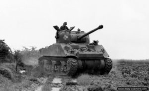 Un char Sherman Firefly ayant appartenu au 148th Royal Armored Corps, 33rd Armored Brigade, est capturé et testé par le Schwere Panzer-Abteilung 503 au nord-est de Giberville. Photo : Bundesarchiv