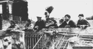 Des habitants de Grandcamp observent les Alliés traverser leur ville. Photo : US National Archives