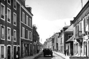 12 juin 1944 : une patrouille américaine sur Jeep traverse les rues de Grandcamp. Photo : US National Archives