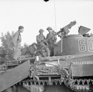 18 juillet 1944 : un chef de char discute avec des soldats sur son char Sherman Crab avant le lancement de l’opération Goodwood, dans le secteur de Hérouvillette. Photo : IWM