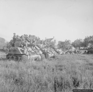 18 juillet 1944 : des chars Sherman attendent l’ordre de progresser dans le cadre de l’opération Goodwood, dans le secteur de Hérouvillette. Photo : IWM