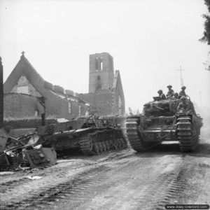 3 août 1944 : un char Churchill transportant des soldats du Royal Scots Fusiliers à proximité de l’épave d’un char allemand Panzer IV à Le Tourneur. Photo : IWM