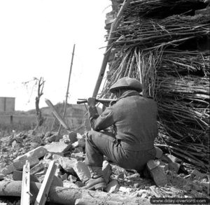 9 août 1944 : un soldat, probablement des Fusiliers Mont Royal, patrouille avec son pistolet mitrailleur Sten. Photo : IWM