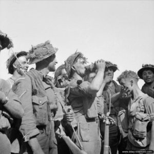 7 août 1944 : le sergent Clifford Brown du Somerset Light Infantry étanche sa soif aux côtés de sa section pendant l’attaque du Mont-Pinçon. Photo : IWM
