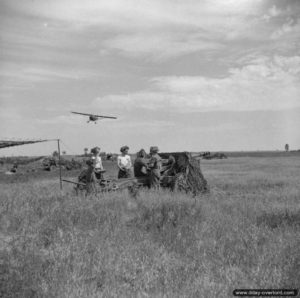 6 juillet 1944 : un appareil de reconnaissance Auster Mk IV AOP du 652 Squadron s’apprête à survoler une batterie de canons de campagne QF 25 Pounder au nord de Plumetot, à proximité de l’aérodrome ALG B-10. Photo : IWM