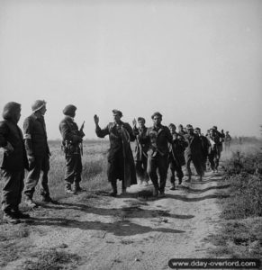 Des soldats canadiens de la 8th Infantry Brigade escortent des prisonniers allemands dans le secteur de Ranville. Photo : IWM