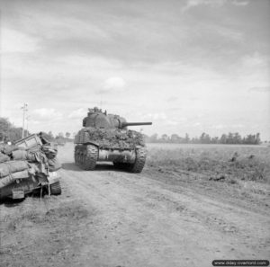 28 juin 1944 : un char Sherman du 4/7th Dragoon Guards, 8th Armoured Brigade, progresse dans le secteur de Rauray pendant l’opération Epsom. Photo : IWM