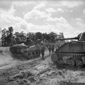 28 juin 1944 : des chars Sherman du 4/7th Dragoon Guards, 8th Armoured Brigade, s’apprêtent à passer à l’action dans le secteur de Rauray pendant l’opération Epsom. Photo : IWM