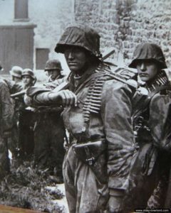 9 juin 1944 vers 14h30 à Rots : le SS-Sturmmann Otto Funk (blessé le 26 juin 1944), de la SS-Aufklärungs Kompanie 15, avec une boîte de munitions pour mitrailleuse MG 42. Photo : Bundesarchiv