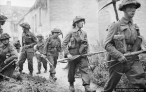 26 juin 1944 : des soldats du 6th Royal Scots Fusiliers, 15th (Scottish) Division, progressent dans le village de Saint-Manvieu-Norrey pendant l’opération Epsom. Photo : IWM