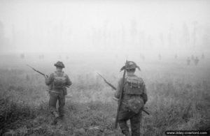 26 juin 1944 : des éléments de la 12ème section de la B Company, 6th Royal Scots Fusiliers, 15th (Scottish) Division, progressent à travers la brume au début de l’opération Epsom dans le secteur de Saint-Manvieu-Norrey. Photo : IWM