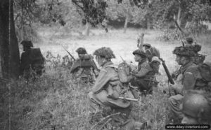 26 juin 1944 : des éléments de la 12ème section de la B Company, 6th Royal Scots Fusiliers, 15th (Scottish) Division, attendent l’ordre de progression dans un verger au début de l’opération Epsom dans le secteur de Saint-Manvieu-Norrey. Photo : IWM