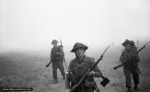 26 juin 1944 : des éléments de la 12ème section de la B Company, 6th Royal Scots Fusiliers, 15th (Scottish) Division, progressent à travers la brume au début de l’opération Epsom dans le secteur de Saint-Manvieu-Norrey. Photo : IWM