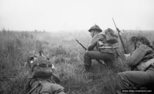 26 juin 1944 : des éléments de la 12ème section de la B Company, 6th Royal Scots Fusiliers, 15th (Scottish) Division, attendent l’ordre de progression au début de l’opération Epsom dans le secteur de Saint-Manvieu-Norrey. Photo : IWM