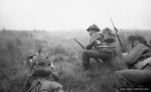 26 juin 1944 : des éléments de la 12ème section de la B Company, 6th Royal Scots Fusiliers, 15th (Scottish) Division, attendent l’ordre de progression au début de l’opération Epsom dans le secteur de Saint-Manvieu-Norrey. Photo : IWM