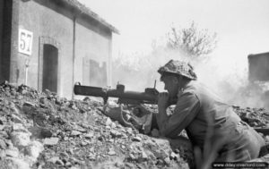 1er août 1944 : un soldat tire une roquette de PIAT dans Saint-Martin-des-Besaces. Photo : IWM
