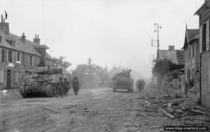 31 juillet 1944 : des chars Sherman et des soldats traversent Saint-Martin-des-Besaces. Photo : IWM