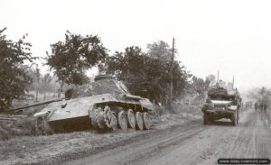 Un half-track roule à proximité d’un char Panther D détruit sur la route nationale 175 à hauteur de Tourville-sur-Odon. Photo : IWM