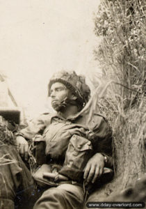 Un parachutiste britannique se repose à l’abri d’une haie dans le secteur de Varaville. Photo : IWM