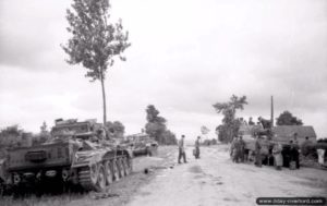 A proximité du point coté 213 à Villers-Bocage, les épaves de deux chars Cromwell à gauche et d’un char Sherman Firefly à droite inspectés par les soldats allemands. Photo : Bundesarchiv