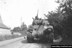Le 7 juin 1944, des renforts américains et notamment ce char M4 Sherman se dirigent depuis Vierville-sur-Mer vers la batterie allemande de la Pointe du Hoc. Photo : US National Archives