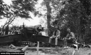 Le 1st Sergeant Leonard G. Lomell et le Staff Sergeant Jack E. Kuhn sur l'un des canons de 155 mm détruits au sud de la Pointe du Hoc. Photo : US National Archives