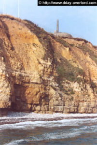 Les falaises à l'est de la Pointe du Hoc, vue de la mer. Le poste de direction des tirs et le monument des Rangers est visible au sommet (2005). Photo : D-Day Overlord