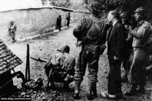 Des combattants américains prennent du renseignement sur l'ennemi auprès d'un civil normand entre Grandcamp et la Pointe du Hoc