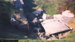 Bunker de la Pointe du Hoc détruit lors du largage par erreur, après le Jour-J de bombes sous-marines-allemandes par la Luftwaffe, visant initialement l'armada alliée. A l'intérieur se trouvaient des prisonniers allemands lors de l'écroulement. Photo (2003) : D-Day Overlord