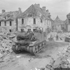 Août 1944 : un obusier M7 Sexton automoteur traverse les ruines de Putanges. Photo : IWM