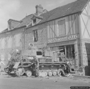 Août 1944 : l’épave d’un char allemand inspecté par les militaires britanniques et la population normande à Putanges. Photo : IWM