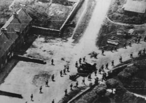 Des soldats américains appartenant au 39th Infantry Regiment de la 9th Infantry Division progressent en double colonne à travers le bourg de Saint-Jacques-de-Néhou, libéré le 17 juin 1944. Un half-track M3 tracte un canon antichar de 57 mm. Photo : US National Archives