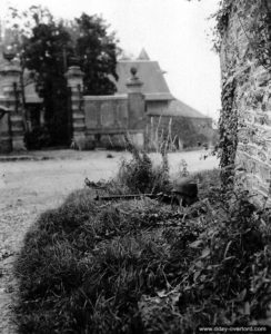 Un soldat américain est posé devant l'entrée du château de Commines, qui fut le quartier-général du 84ème corps d'armée allemand, à Saint-Lô. Photo : US National Archives