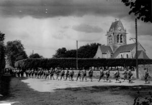 Des fantassins traversent Sainte-Mère-Eglise afin de rejoindre la ligne de front. Photo : US National Archives