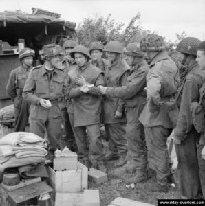 Le "Padre" du 13th-18th Royal Hussars, le révérend Victor Leach, distribue des cigarettes le 7 juin 1944. Photo : IWM