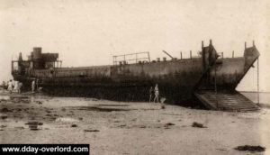 Carte postale de la commune de Langrune-sur-Mer après le débarquement illustrant un LCT abandonné