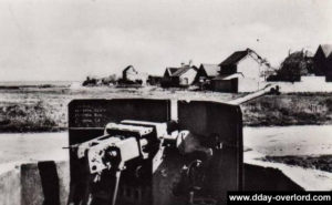 Carte postale de Lion-sur-Mer après le débarquement, où les vestiges des défenses allemandes sont encore visibles, en particulier ce canon de 50 mm antichar allemand