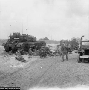 Prise en compte des blessés par le 5th Assault Regiment Royal Engineers derrière un char Avre. Photo : IWM