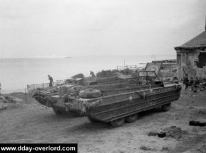 A Luc-sur-Mer après le débarquement, des véhicules amphibies DUKW sont stationnés à proximité des maisons détruites par les combats. Photo : IWM