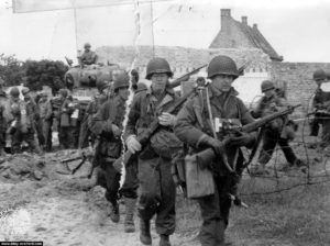 Les soldats et les chars vers l'intérieur des terres, devant la "Maison Rouge". Photo : US National Archives