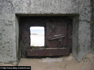 Créneau de défense avec plaque de blindage mobile pour mitrailleuse MG type 483 P2 sur le point d'appui Wn 10 des Dunes-de-Varreville à Utah Beach. Photo : D-Day Overlord