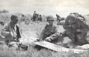 Les généraux Raymond O. Barton (au centre) et Theodore Roosvelt, Jr (à gauche), à la tête de la 4th (US) Infantry Division, effectuant un point de situation après le débarquement à Utah Beach le Jour-J. Photo : US National Archives