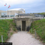 Entrée de souterrain du point fortifié W5 d'Utah Beach. En arrière-plan, le musée d'Utah Beach. Photo : D-Day Overlord