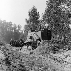 Dans le secteur de Blainville-sur-Orne le 18 juillet 1944 (jour du déclenchement de l'opération Goodwood), un bulldozer blindé Caterpillar D7 réalise des travaux de terrassement dans le cadre de la mise en place du pont de bateaux baptisé "Tay 2" sur l'Orne. Les sapeurs appartiennent aux Royal Engineers. Photo : Ralph Morse pour LIFE Magazine