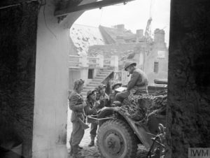 Juin 1944 : le Captain J. F. Burgess, appartenant au Royal Artillery, donne des éléments tactiques à une de ses équipes d'observateurs avancés avant leur départ en mission. Ils se déplacent à bord d'un véhicule blindé (ici un M4 Half-Track) puis rejoignent la ligne de front à pied en toute discrétion. Photo : IWM A 24347