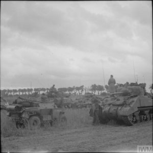 26 juin 1944 : un véhicule de reconnaissance Scout Car et des chars M4 Sherman appartenant à l'état-major de la 29th Armoured Brigade, 11th (GB) Armoured Division pendant l'opération Epsom. Photo : IWM B 6019