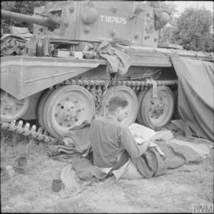 15 juin 1944 : l'équipage anglais d'un char Cromwell appartenant à l'état-major de la 22nd Armoured Brigade, 7th (GB) Armoured Divsion, se repose à proximité immédiate de leur engin, près d'une haie normande. Le repas agrémenté d'une bouteille de cidre ou de calvados est encore sur le char. Photo : IWM B 5598