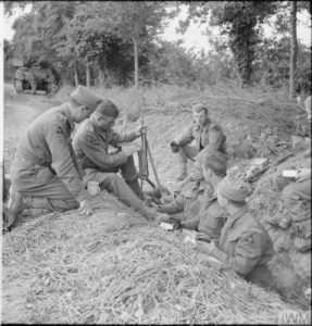13 juin 1944 : des soldats anglais du South Lancashire Regiment (3rd GB Infantry Division) inspectent un pistolet-mitrailleur MP40 pris à l'ennemi. Photo : IWM B 5547
